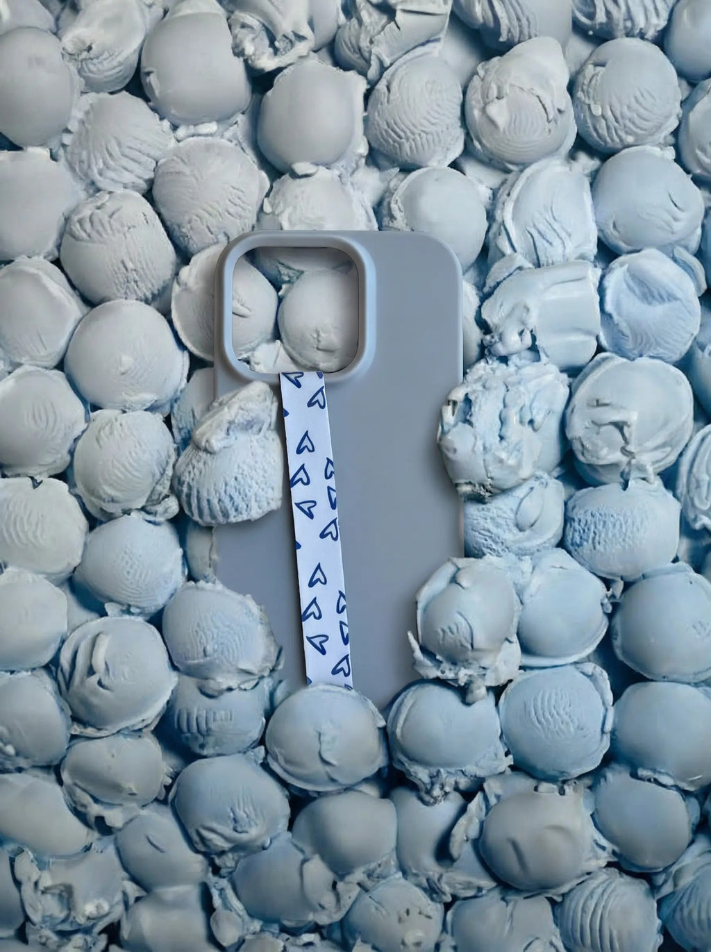 Velnoon Blue Crush telefoonbandje met bijpassend telefoonhoesje, gestyled met blauwe ijsbolletjes in een speelse sfeerfoto