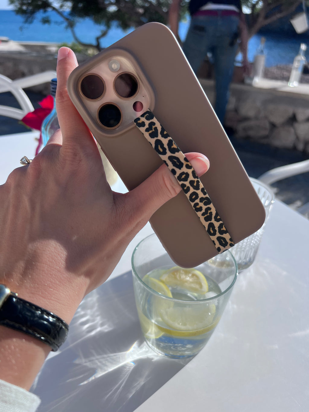 Velnoon Golden Leopard telefoonbandje gedragen in de hand, elegante phone strap