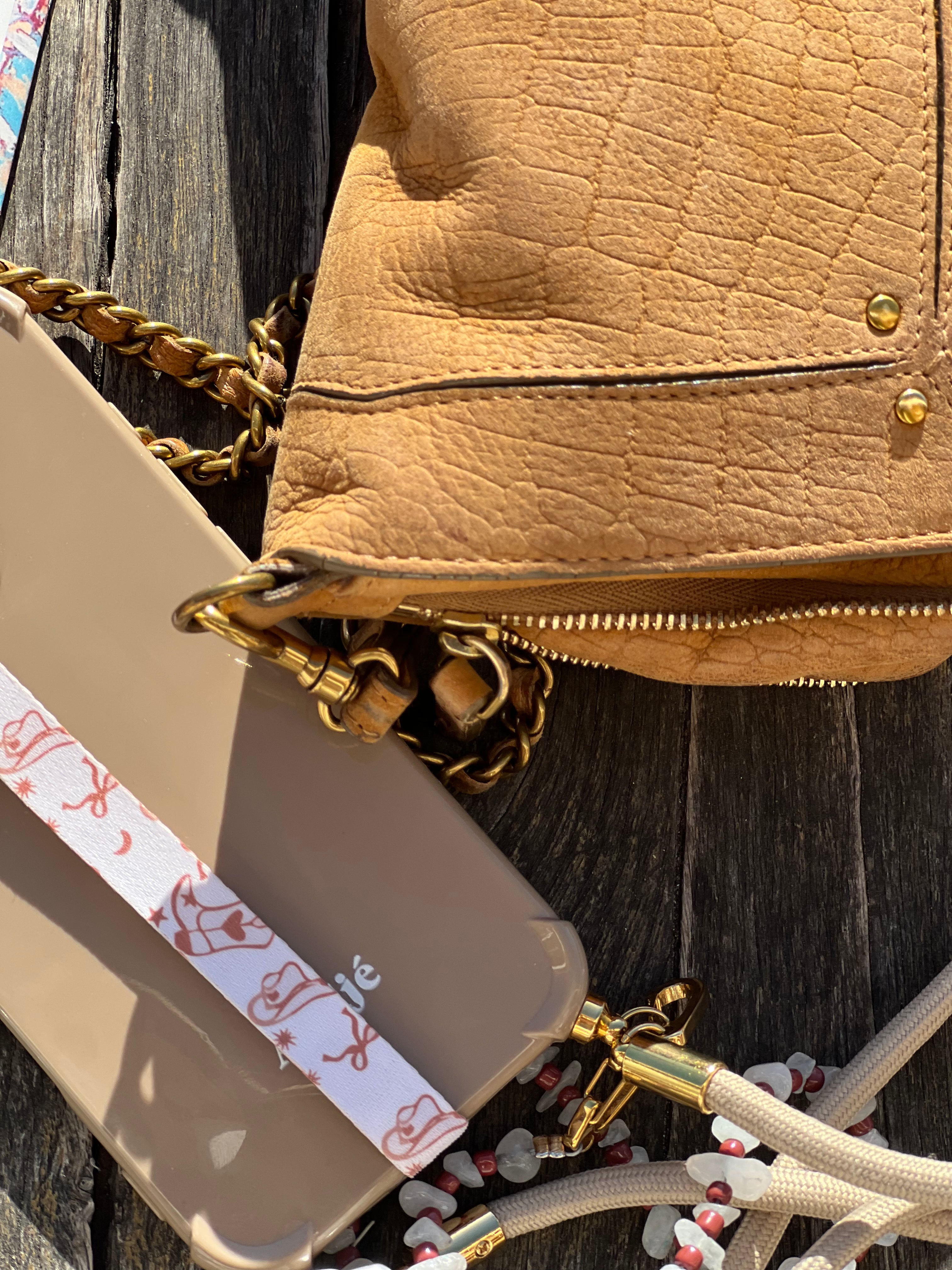 Velnoon phone strap met Boots & Bows design gestyled als flatlay, stijlvol telefoon bandje